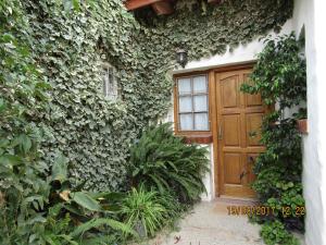 a building with a wooden door with ivy on it at Calfulauquen in Las Grutas