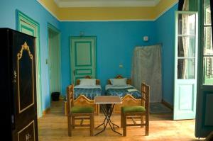 una camera da letto con pareti blu, tavolo e sedie di Berlin Hotel a Il Cairo
