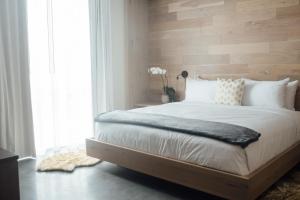 a bedroom with a large bed with a wooden wall at The Preston House and Hotel in Riverhead