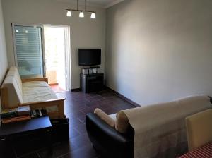 a living room with a couch and a tv at Faro Downtown Holiday Apartment in Faro