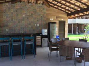 a restaurant with tables and chairs and a counter at Vilage beira mar in Itacimirim