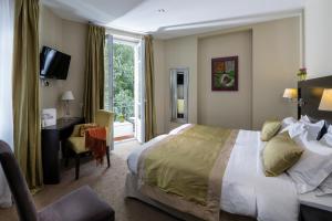 a hotel room with a bed and a desk and a window at La Place Boutique Hotel in Antibes