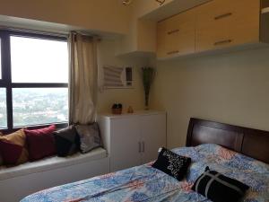 a bedroom with a bed and a window at KC Studio 5 at Horizon 101 Cebu in Cebu City