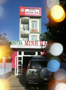 un coche aparcado frente a un hotel con un cartel en Minh Ha Hotel, en La Gi