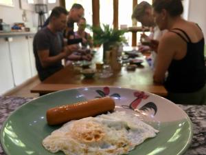 a plate of food with a sausage and eggs on a table at Victory Park Hostel in Bangkok