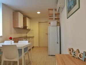 a kitchen with a white table and a refrigerator at Istrian Sunrise in Koper