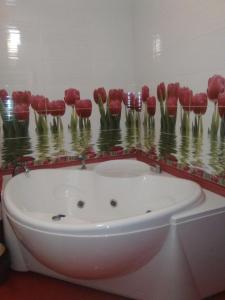 bañera con flores rojas en la pared en Apartments Galactika, en Uralsk
