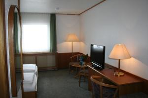 a hotel room with a desk with a computer on it at Landhotel Margaretenhof in Erzhausen