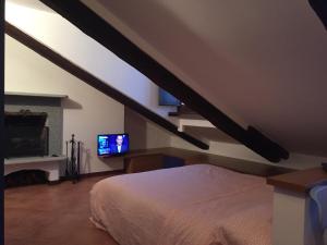 ein Schlafzimmer mit einem Bett und einem TV an der Wand in der Unterkunft Quintino 15 in Turin