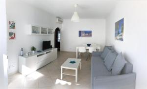 een witte woonkamer met een bank en een tafel bij Apartamento Praia Altura - Terraço BBQ - Wifi - AC - Garagem Fechada in Altura