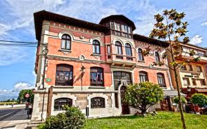 a large brick building on the side of a street at Hotel Casona del Sella in Arriondas