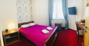 a bedroom with a red bed with two towels on it at Villa Kabbalah in Gdańsk