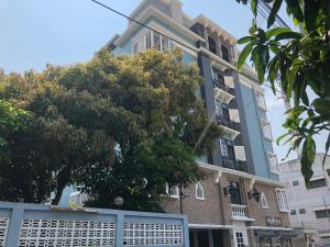 un bâtiment avec un arbre en face dans l'établissement M. Swita เอ็ม.สวิต, à Bangkok