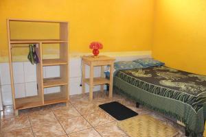 1 dormitorio con cama, mesa y estante en Una Noche Con Mical, en San Pedro La Laguna