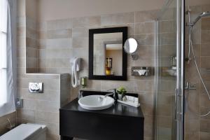 a bathroom with a sink and a shower at La Place Boutique Hotel in Antibes