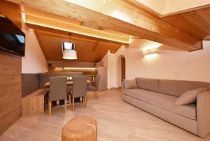 ein Wohnzimmer mit einem Sofa und einem Tisch in der Unterkunft Appartamenti Maria in Canazei