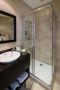 a bathroom with a sink and a shower at La Place Boutique Hotel in Antibes