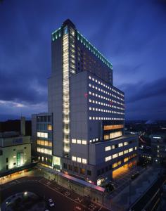 um edifício alto com luzes acesas numa cidade em Hotel Green Park Tsu em Tsu