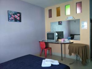 Zimmer mit einem Schreibtisch mit einem Computer und einem roten Stuhl in der Unterkunft The Star Villa Resort in Hat Yai