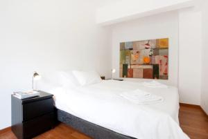 アテネにあるArtistic 2 bedroom apt in Athens centre! LA1の白いベッドと壁に絵画が飾られたベッドルーム1室
