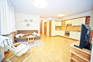 a living room with a couch a table and a tv at Apartamenty Haffnera by Grand Apartments in Sopot