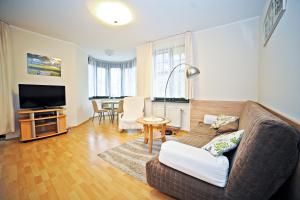 a living room with a couch and a television at Apartamenty Haffnera by Grand Apartments in Sopot