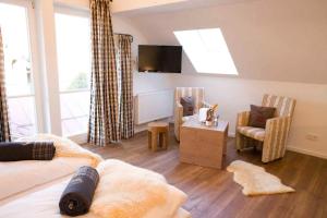 ein Wohnzimmer mit einem Sofa und einem TV in der Unterkunft Alpin Lifestyle Hotel Löwen & Strauss in Oberstdorf