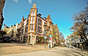a tall building with a clock tower on a street at Red Apartment Czyżewskiego by Grand Apartments in Sopot