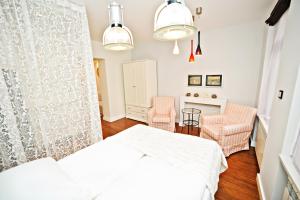sypialnia z białym łóżkiem i 2 krzesłami w obiekcie Amber Apartment by Grand Apartments w mieście Sopot