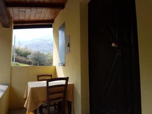 tavolo e sedie in una stanza con finestra di La Cantina a Morano Calabro