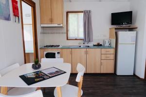 a kitchen with a white table and a white refrigerator at Euroa Caravan Park in Euroa