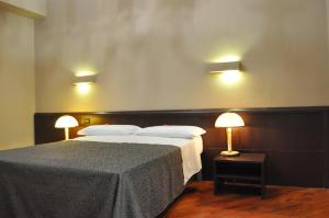 a bedroom with a large bed with two lamps at Hotel Twenty Nine in Genoa