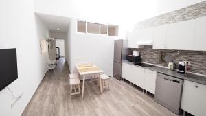 uma cozinha com armários brancos e uma mesa em Spaceous 2 BR in Central Alicante em Alicante
