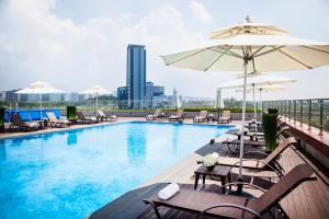 a swimming pool with chairs and umbrellas on a building at Sono Calm Goyang in Goyang