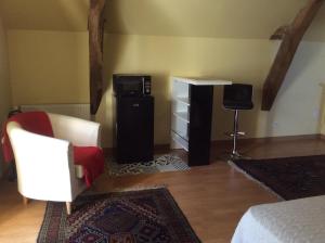 a bedroom with a bed and a microwave and a television at Domaine de la Houzardiere in Bazougers
