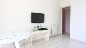 uma sala de estar com uma mesa e uma televisão na parede em Résidence Rauba Capeu em Nice