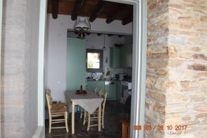 una cucina e una sala da pranzo con tavolo e sedie di Sunrise Stone Residence ad Andro