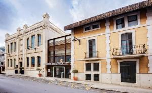 un antiguo edificio al lado de una calle en Hotel Sercotel Ciutat D'Alcoi, en Alcoy