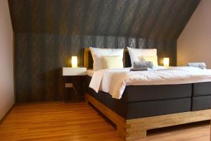 a bedroom with a large bed with two lights on it at Holiday Home Kötz in Günzburg