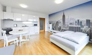 a white bedroom with a white bed and a table at Garden Towers Apartments in Prague