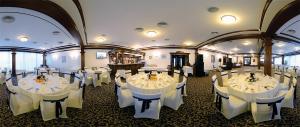 a banquet hall with white tables and white chairs at Hotel Diesel in Bucharest