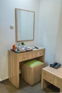 
a small bathroom with a wooden table and a mirror at Anita Hotel in Piraeus
