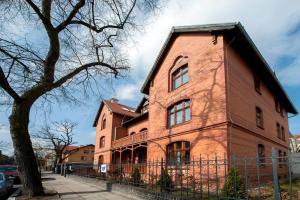 a large red brick building with a black roof at Very Berry - Orzeszkowej 16 - MTP Apartment, parking, check in 24h in Poznań