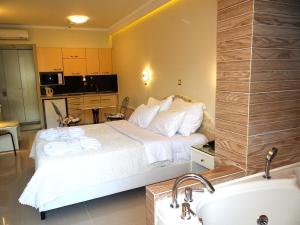 a bedroom with a bed and a bathroom with a sink at Hotel Aeollos in Pefkochori