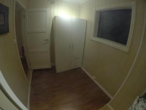a hallway with a white refrigerator and a window at Apartment near the airport in Tromsø