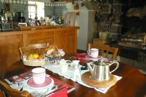 a table with a tea kettle and a basket of fruit at chez Geppetto in Saint-Georges-Nigremont