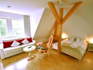 Zimmer mit einem Bett, einem Sofa und einem Stuhl in der Unterkunft Ferienwohnung "Zum Postamt" in Binz
