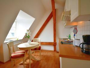 eine Küche mit einem Tisch und Stühlen im Zimmer in der Unterkunft Ferienwohnung "Zum Postamt" in Binz