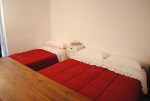 Parte di casa con giardino e piscina في بيتراسانتا: سريرين في غرفة نوم وبطانيات حمراء وبيضاء