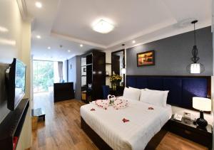 a bedroom with a large white bed with flowers on it at Bella Rosa Trendy Hotel & Spa in Hanoi